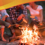 People sitting around a fire roasting marshmallows